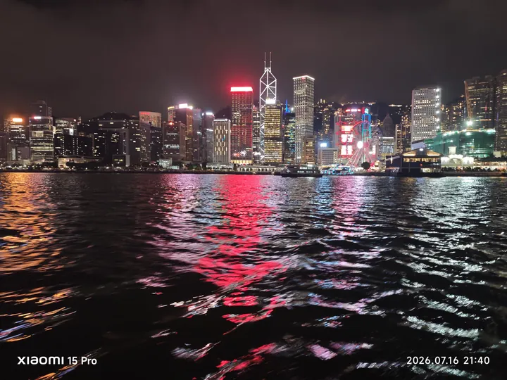 维港夜间楼群与红色灯光在水面的倒影